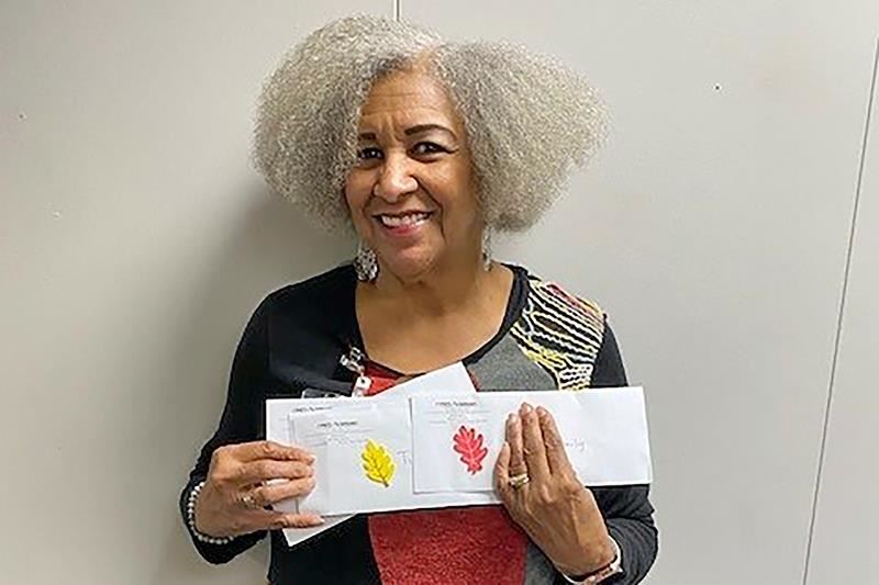 Sharon Bey, Families in Transition counselor, poses with gift cards that were delivered to families.